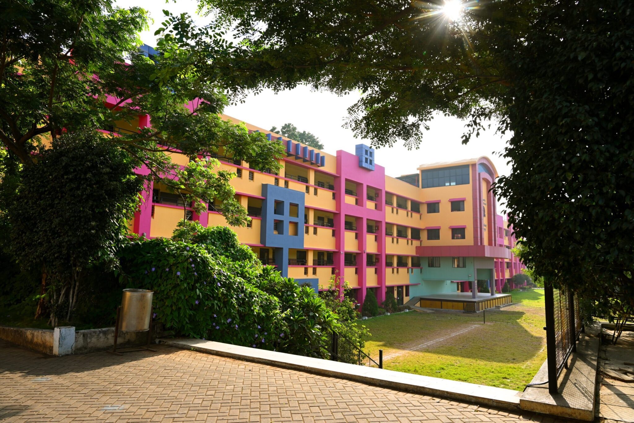 The colourful facade of St. Arnold's Central School, framed by trees